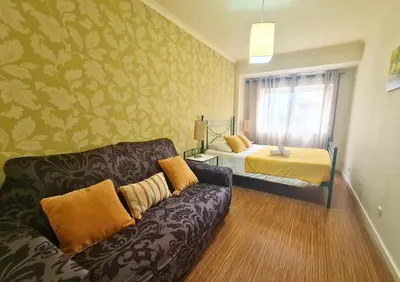 a living room with a couch and a bed at D Joao Premium Suite Bolhao Metro in Porto