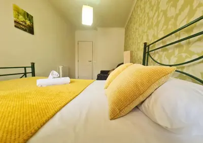 a bedroom with a bed with yellow and white pillows at D Joao Premium Suite Bolhao Metro in Porto