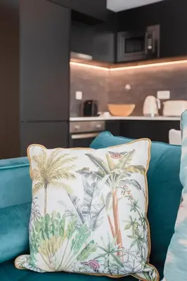 a pillow on a couch with palm trees on it at GuestReady - Soho urban retreat in Porto