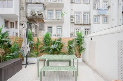 a green bench on a balcony with buildings at GuestReady - Soho urban retreat in Porto