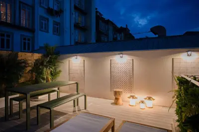 a patio with two benches and lights on a building at GuestReady - Soho urban retreat in Porto