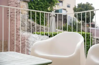 a white chair and a table on a balcony at Modern 1BR Apartment - Brand New Bonjardim I in Porto