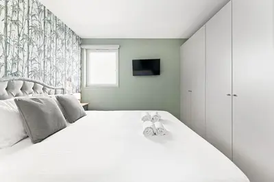 a bedroom with a white bed with two stuffed animals on it at Stay Bonjardim - Modern Garden Duplex M in Porto