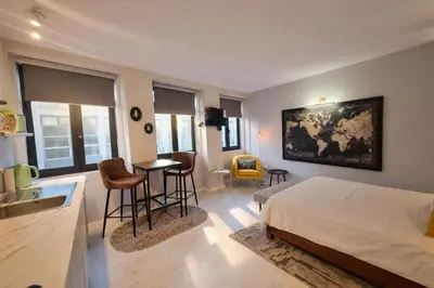 a bedroom with a bed and a table and chairs at Lovely Studio in the Heart of Historic Porto in Porto