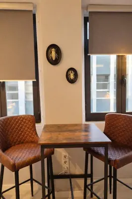 a dining room table and two chairs with windows at Lovely Studio in the Heart of Historic Porto in Porto
