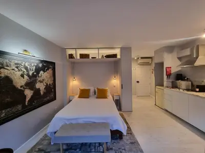 a bedroom with a large bed and a kitchen at Lovely Studio in the Heart of Historic Porto in Porto