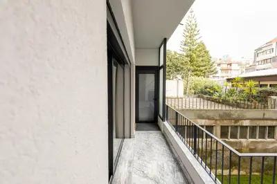 a bedroom with a white bed and a window at Music Apartment II in Bicas