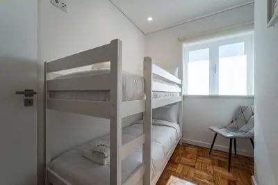 a bedroom with a large white bed with a window at T4 ForYou Oporto Downtown in Porto