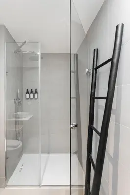 a shower with a glass door in a bathroom at Stay Bonjardim - Modern Garden Duplex N in Porto