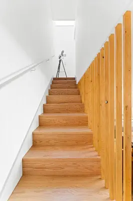 a staircase in a house with wooden floors and a camera at Stay Bonjardim - Modern Garden Duplex N in Porto