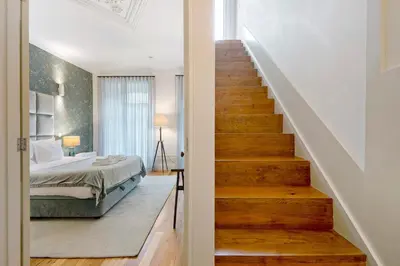 a stairway leading to a bedroom with a bed at Alma D'oporto 556 – Elegant T1 in Porto