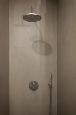 a bathroom with a shower with a light on the wall at Modern Flat With Balcony on Rua das Flores - 1st in Porto