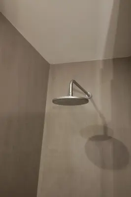 a shower with a shower head on a wall at Modern Flat With Balcony on Rua das Flores - 1st in Porto