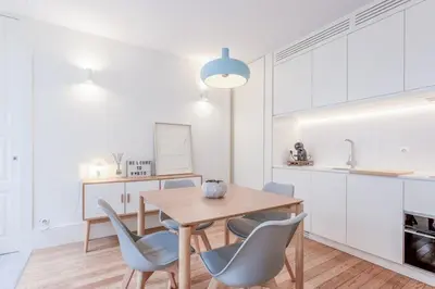 a kitchen and dining room with a wooden table and chairs at Modern Flat With Balcony on Rua das Flores - 1st in Porto