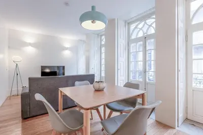 a dining room with a wooden table and chairs at Modern Flat With Balcony on Rua das Flores - 1st in Porto