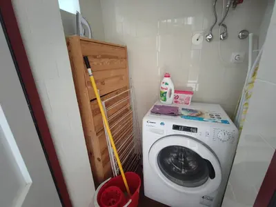 a small laundry room with a washing machine and a mop at Breiner House Porto in Porto