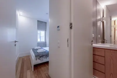 a white bathroom with a shower and a sink at Modern Flat with balcony on Rua das Flores - 2nd in Porto
