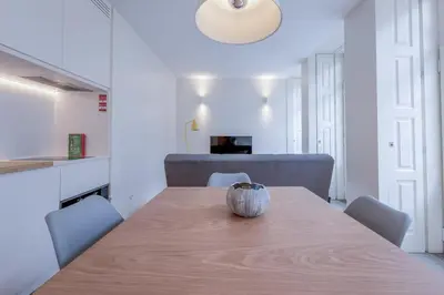 a dining room table with chairs and a vase on it at Modern Flat with balcony on Rua das Flores - 2nd in Porto