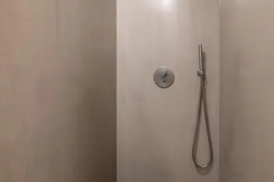 a shower with a hose attached to a white wall at Modern Flat with balcony on Rua das Flores - 2nd in Porto