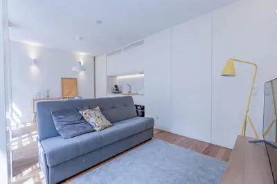a living room with a blue couch in a room at Modern Flat with balcony on Rua das Flores - 2nd in Porto