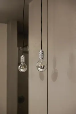 two lights hanging from a wall in a room at Modern Flat on Rua das Flores - 4th Floor in Porto