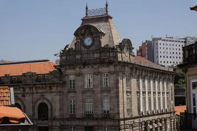 an old building with a clock tower on top of it at Modern Flat with balcony on Rua das Flores - 5th in Porto