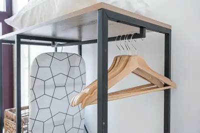 a shelf with wooden hangers in a room at GuestReady - Douro D'or Apartments in Vila Nova de Gaia