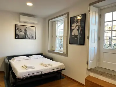 a bedroom with a large bed with yellow pillows at Clérigos Cinema Guesthouse in Porto
