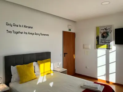 a bedroom with a bed with two towels on it at Clérigos Cinema Guesthouse in Porto