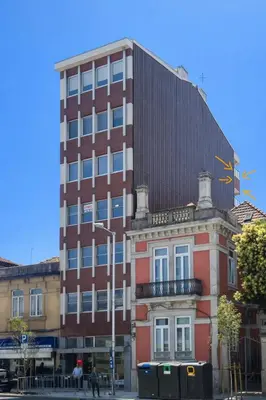 a tall red brick building next to a building at Good View Studio in Porto