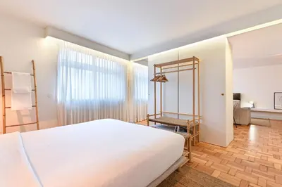 a bedroom with a large white bed and a window at Sleep in Office by ON Apartments in Porto