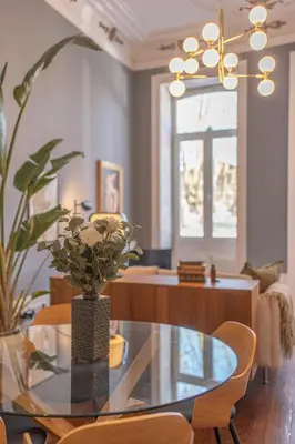 a dining room with a glass table and a chandelier at Historic Porto Stay, Classic Details, City Life in Porto