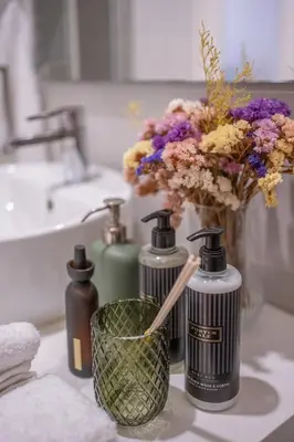 a bathroom with two bottles of soap and a vase of flowers at Historic Porto Stay, Classic Details, City Life in Porto