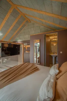 a bedroom with a large bed in front of a kitchen at Hut E, Cabana in Town in Porto