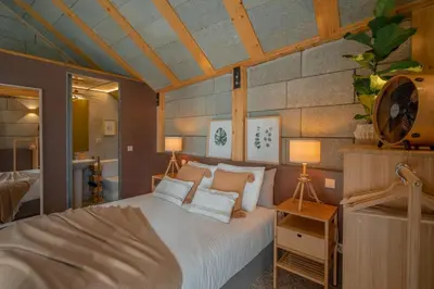 a bedroom with a bed with two lamps and a tub at Hut E, Cabana in Town in Porto