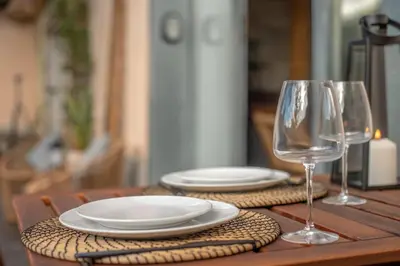 a wooden table with plates and wine glasses on it at Hut E, Cabana in Town in Porto