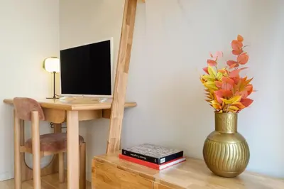 a desk with a computer and a vase with flowers at Luxury Style 5 with AC Downtown Porto near Metro in Porto