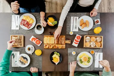 a group of people sitting around a table with breakfast foods at HF Ala Sul in Porto