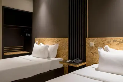 two beds with white pillows in a hotel room at HF Ala Sul in Porto