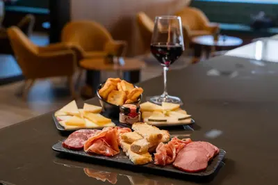 a table with a plate of food and a glass of wine at HF Ala Sul in Porto