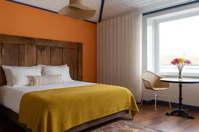a bedroom with a bed and a table and a window at Miragaia House in Porto
