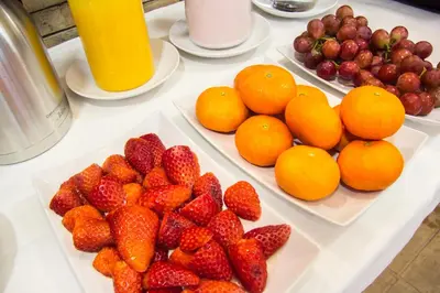 a table topped with plates of strawberries and oranges at Miragaia House in Porto