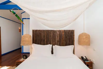 a bedroom with a bed with white sheets and a canopy at Miragaia House in Porto