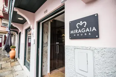 a sign for a macaria house on the side of a building at Miragaia House in Porto