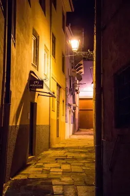 an empty alley at night with a street light at Miragaia House in Porto