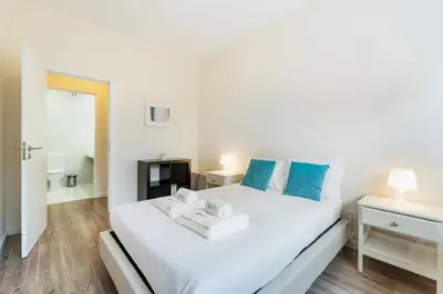 a bedroom with a large white bed with blue pillows at GuestReady - Cosy family home in the Bonfim area in Porto
