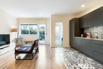 a living room with a couch and a tv and a kitchen at GuestReady - Cosy family home in the Bonfim area in Porto