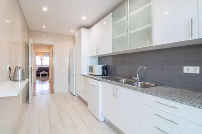 a kitchen with white cabinets and a sink at Violet House by LovelyStay in Vila Nova de Gaia