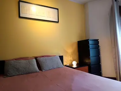 a bedroom with a bed and a yellow wall at Glimpses of Australia in Porto