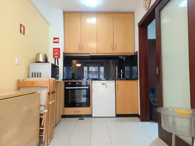 a kitchen with wooden cabinets and a white refrigerator at Glimpses of Australia in Porto